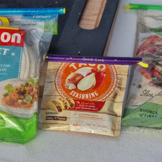 Showing the purple sized Quicklock Bag Sealer being used on a packet of taco seasoning to keep it fresh